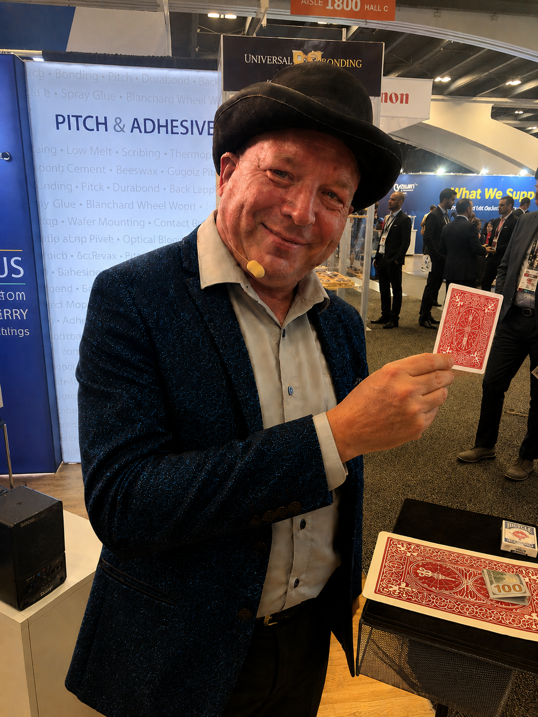 Clive holding up a playing card on a trade show floor.